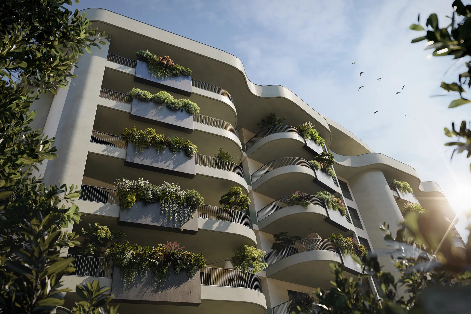 Fonte Laurentina: facciata di edificio moderno con balconi curvi ornati da piante verdi e cielo sereno con uccelli in volo.