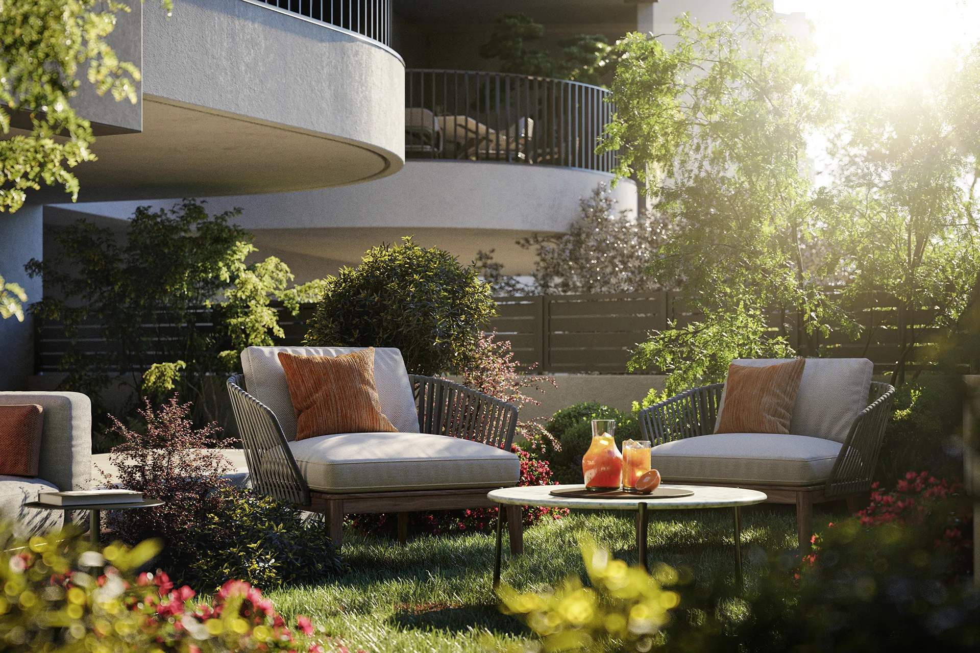 Fonte Laurentina: spazio esterno con due poltrone moderne con cuscini beige e arancioni, tavolino con caraffa e bicchiere di bevanda arancione, circondato da prato e piante verdi soleggiate.